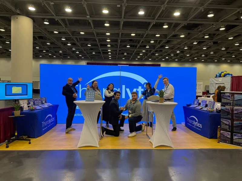 Theralytics team members posing together at their ABA conference booth