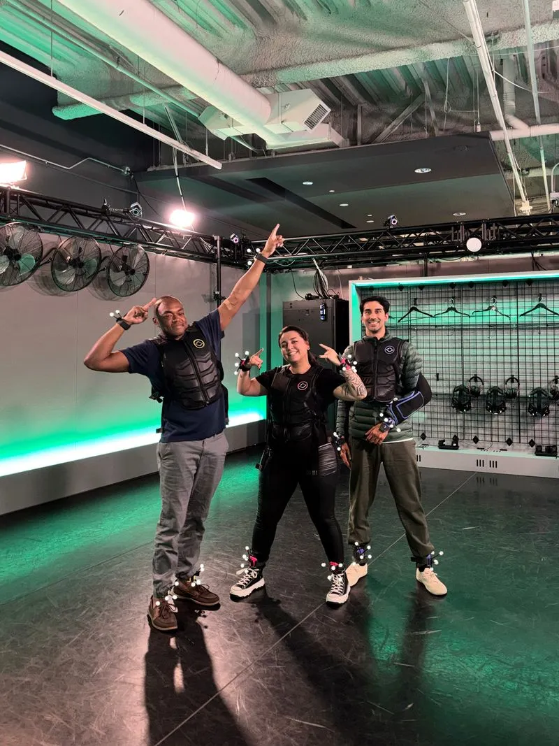 Three Theralytics team members wearing motion-capture vests in an interactive studio