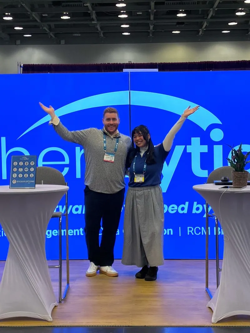 Two Theralytics team members celebrating together at the company ABA conference booth