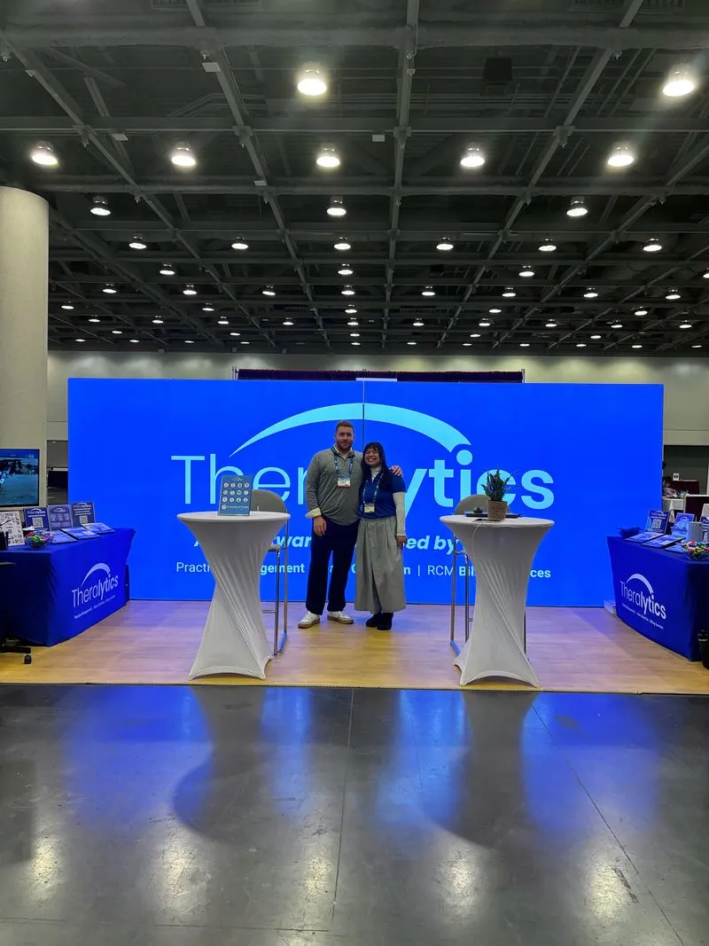 Two Theralytics team members standing together at the company ABA conference booth
